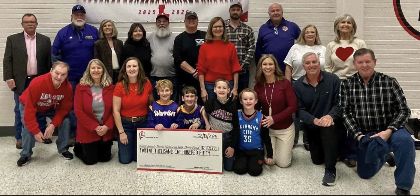 A group holding a check for $12,150 made out to the milk fund