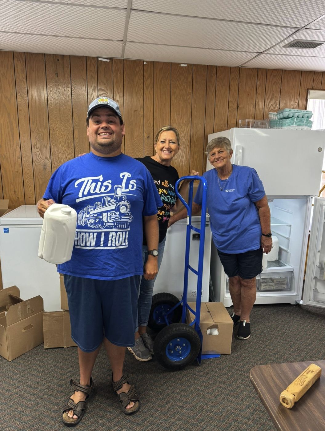 Three pantry volunteers, one holding a gallon of milk